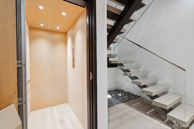 staircase with hardwood / wood-style floors and elevator