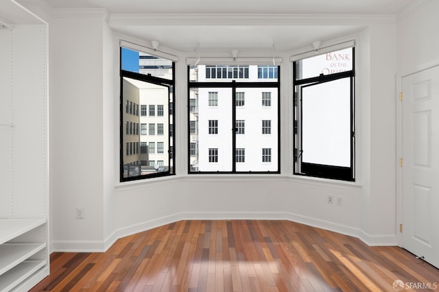 unfurnished room featuring ornamental molding, dark hardwood / wood-style floors, and a wealth of natural light