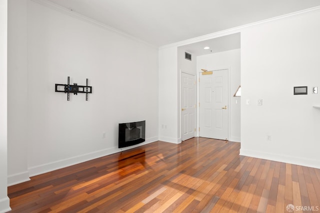 unfurnished living room with wood-type flooring and ornamental molding