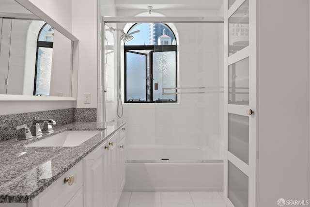 bathroom featuring tiled shower / bath combo and vanity