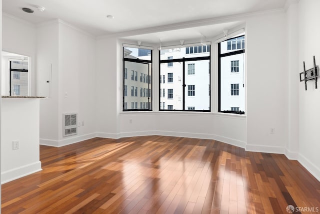 unfurnished room with hardwood / wood-style flooring and ornamental molding