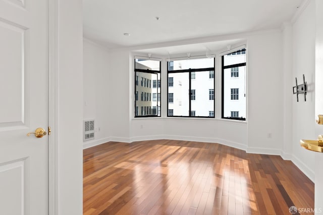 unfurnished room with wood-type flooring and crown molding