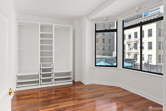 unfurnished bedroom featuring ornamental molding, dark hardwood / wood-style flooring, and multiple windows