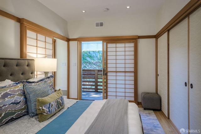 bedroom featuring a closet, light hardwood / wood-style floors, and access to exterior