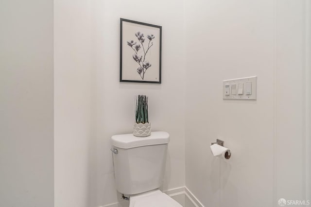 bathroom featuring baseboards and toilet