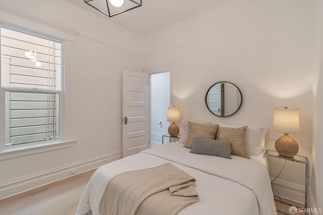 bedroom featuring baseboards and light wood-style flooring