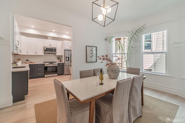 dining room with light wood-style flooring and recessed lighting