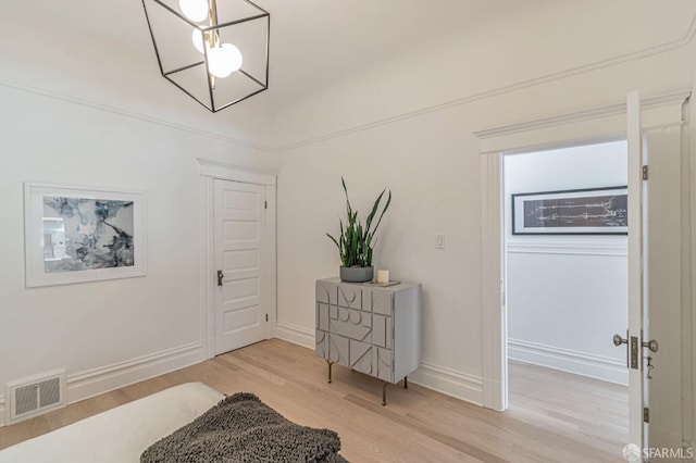 foyer entrance with baseboards, visible vents, and light wood-style floors