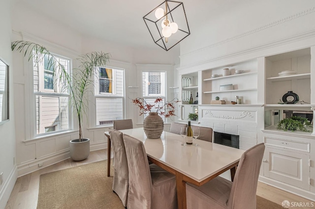 dining room featuring light wood-type flooring and built in shelves