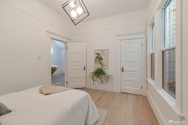 bedroom with baseboards and light wood finished floors