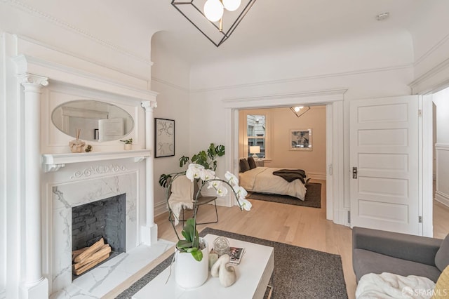 living room with a high end fireplace and wood finished floors