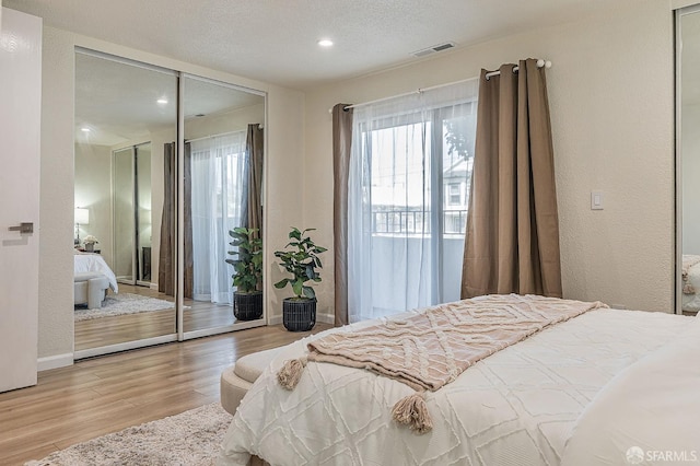 1396 El Camino Real Unit 110, Millbrae, CA 94030 - bedroom with wood finished floors, access to outside, a closet, recessed lighting, and a textured ceiling