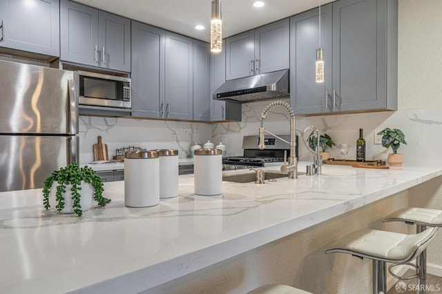 1396 El Camino Real Unit 110, Millbrae, CA 94030 - kitchen with appliances with stainless steel finishes, under cabinet range hood, gray cabinetry, light stone counters, and tasteful backsplash