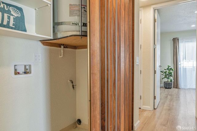 1396 El Camino Real Unit 110, Millbrae, CA 94030 - laundry area with washer hookup, wood finished floors, a textured ceiling, and water heater