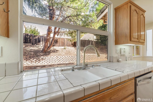 kitchen featuring tile counters, tile patterned flooring, stainless steel dishwasher, and sink