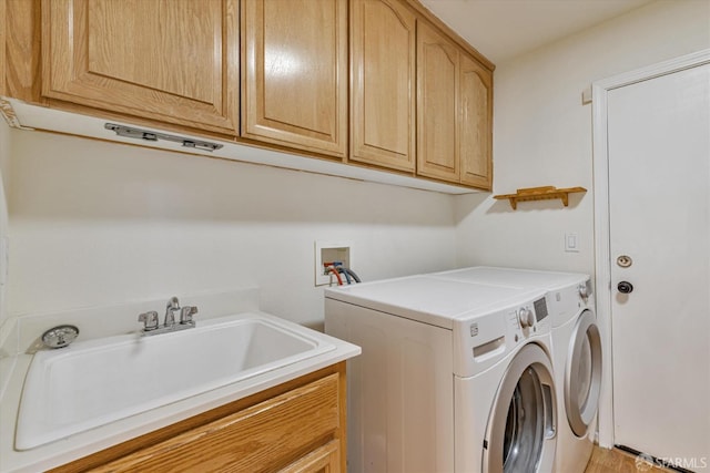 washroom with cabinets, sink, and separate washer and dryer