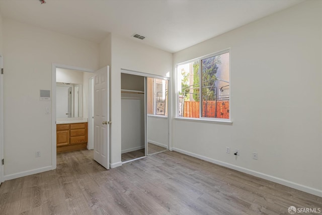 unfurnished bedroom featuring a closet and light hardwood / wood-style floors