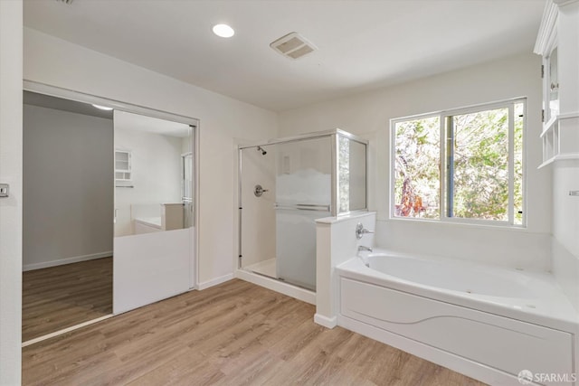 bathroom featuring wood-type flooring and plus walk in shower