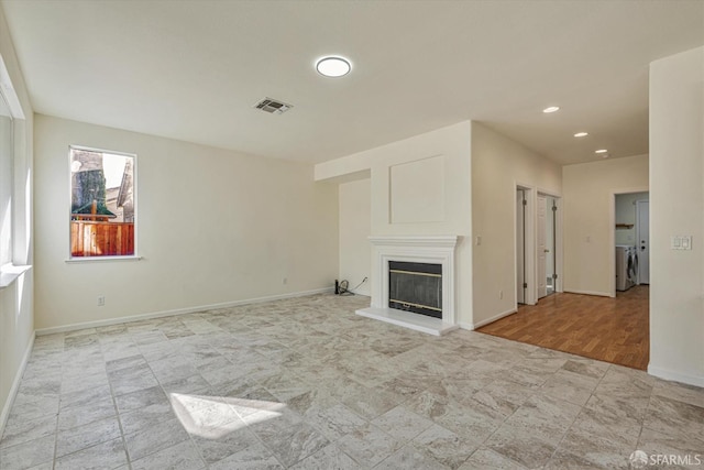 unfurnished living room with separate washer and dryer and light hardwood / wood-style flooring