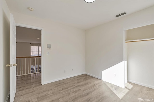 unfurnished bedroom featuring light wood-type flooring and a closet