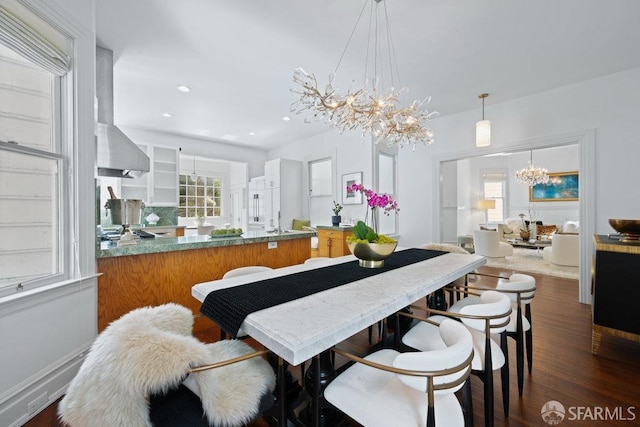 dining room with a chandelier, recessed lighting, a healthy amount of sunlight, and dark wood-type flooring