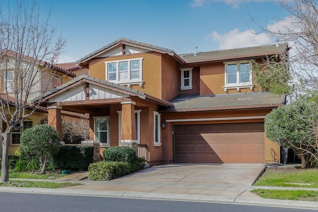 view of front of property with a tile roof, a garage, driveway, and stucco siding