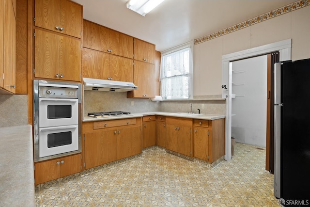 kitchen featuring decorative backsplash, sink, and appliances with stainless steel finishes