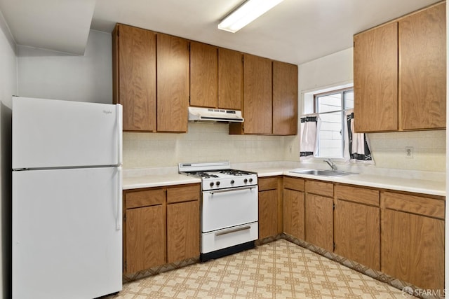 kitchen featuring decorative backsplash, sink, and white appliances