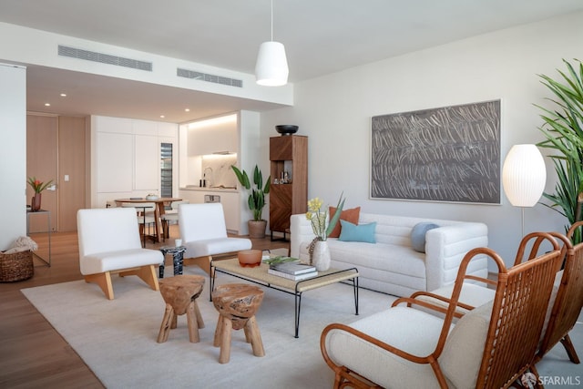 living room featuring light wood-style flooring and visible vents