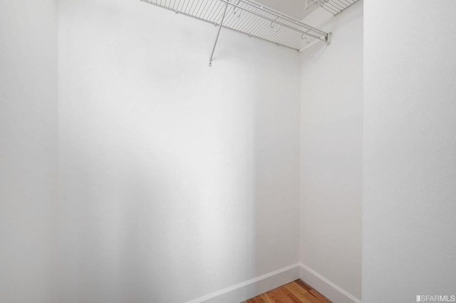 walk in closet with wood-type flooring