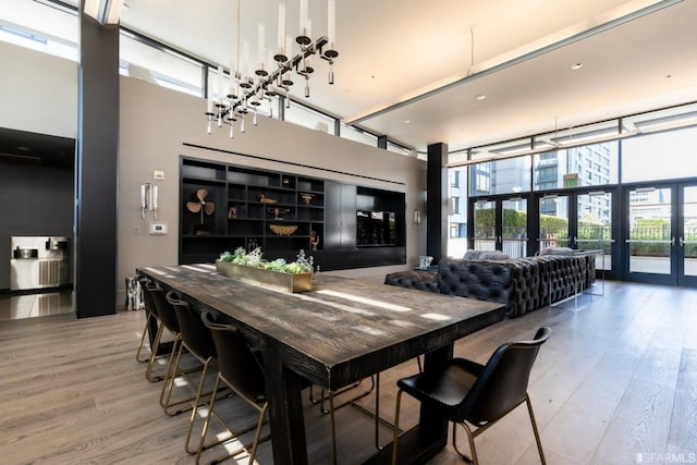 dining space featuring hardwood / wood-style flooring, floor to ceiling windows, and french doors