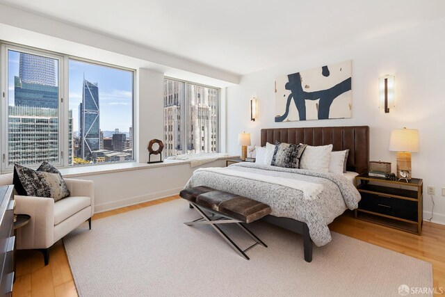 188 Minna St Unit 24A, San Francisco, CA 94105 - bedroom featuring wood finished floors, baseboards, and a city view