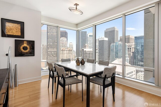 188 Minna St Unit 24A, San Francisco, CA 94105 - dining space featuring light wood-type flooring, baseboards, and a skyline view