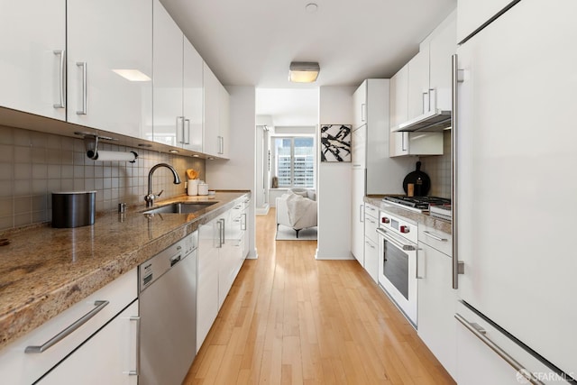 188 Minna St Unit 24A, San Francisco, CA 94105 - kitchen with stainless steel appliances, a sink, decorative backsplash, light wood finished floors, and white cabinetry