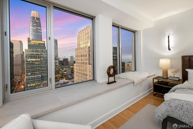 188 Minna St Unit 24A, San Francisco, CA 94105 - bedroom with wood finished floors, a view of city, and baseboards