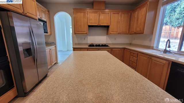 kitchen featuring light tile patterned floors, sink, and black appliances