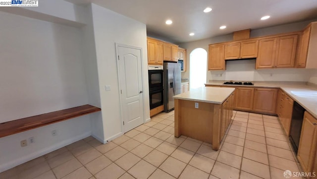 kitchen featuring a kitchen island, black appliances, and light tile patterned floors