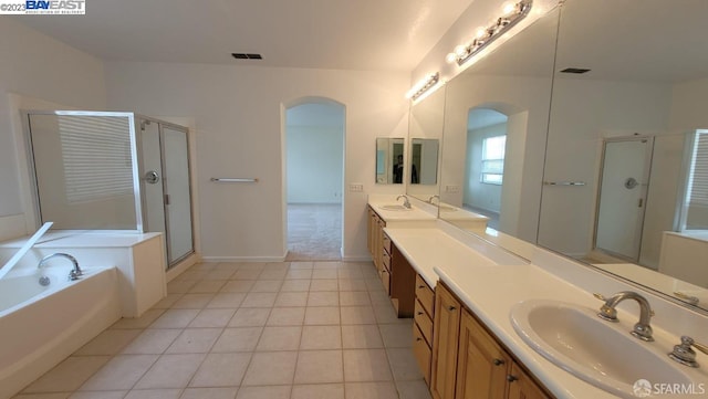 bathroom with tile patterned floors, vanity, and shower with separate bathtub