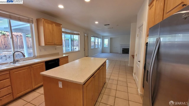 kitchen with stainless steel refrigerator with ice dispenser, sink, light tile patterned floors, dishwasher, and a kitchen island