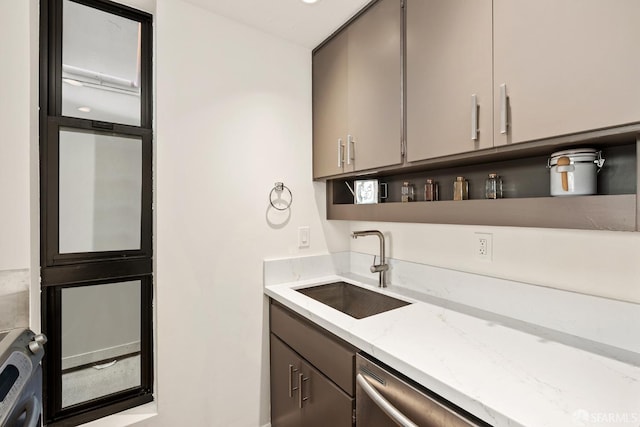 interior space with light stone countertops, sink, and stainless steel dishwasher