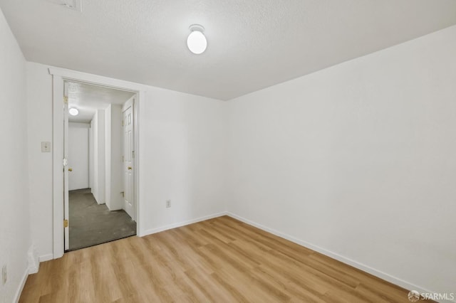 77 Reddy St, San Francisco, CA 94124 - unfurnished bedroom featuring light wood-type flooring, baseboards, and a textured ceiling