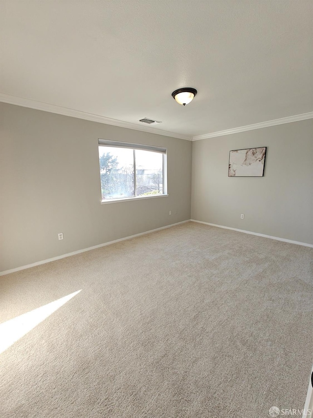 empty room featuring ornamental molding, light carpet, visible vents, and baseboards