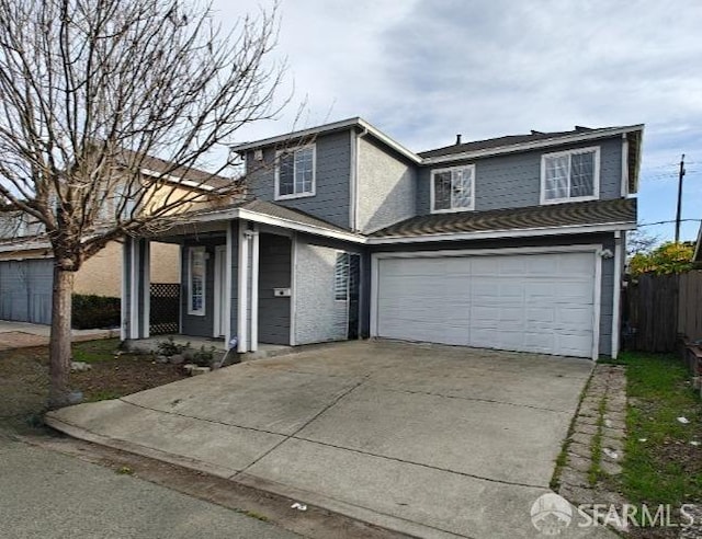 traditional-style home with concrete driveway, an attached garage, and fence