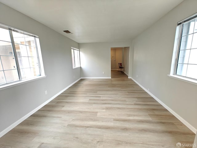 spare room featuring a wealth of natural light and light wood-style flooring