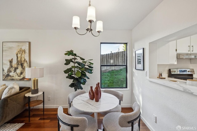 dining space featuring dark hardwood / wood-style flooring, a notable chandelier, and a wealth of natural light