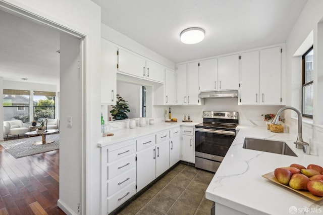 kitchen with stainless steel electric range oven, light stone countertops, sink, and white cabinets