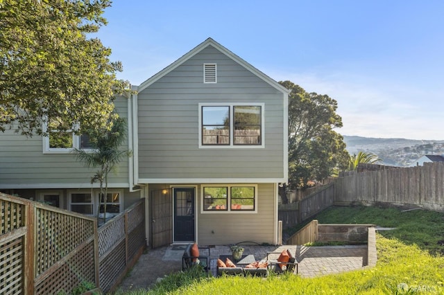 back of house with a patio, a mountain view, a fire pit, and a lawn