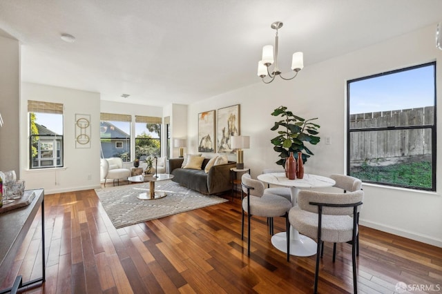 dining space with dark hardwood / wood-style floors and a notable chandelier