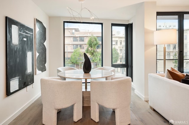 dining area with hardwood / wood-style floors and an inviting chandelier