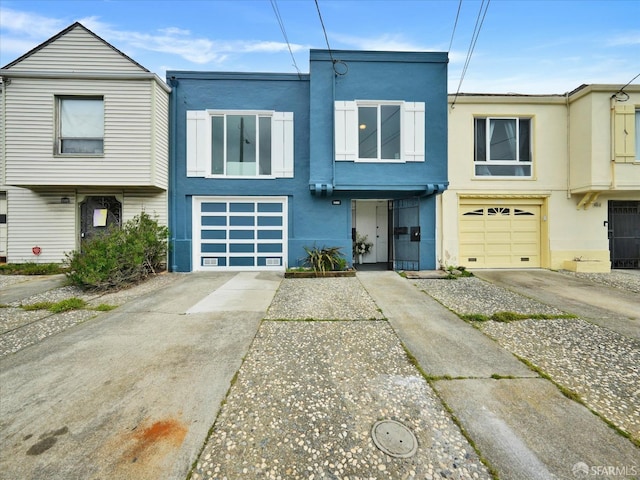 view of front of home featuring a garage, driveway, and stucco siding